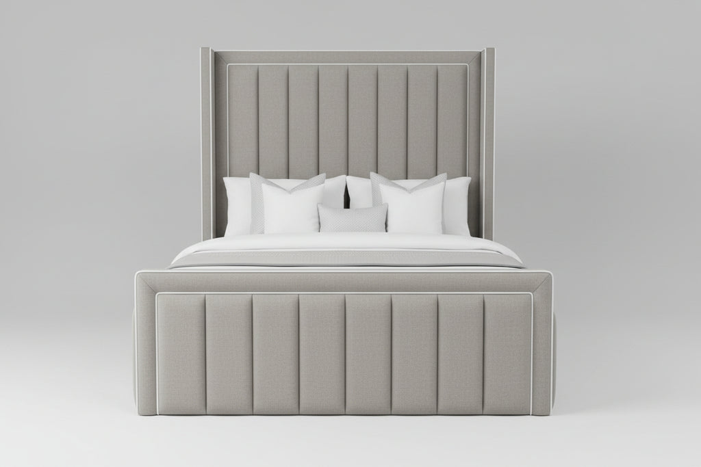 A modern upholstered bed with a tall channel-tufted headboard and matching footboard, dressed in white bedding and a gray throw blanket, shown in a minimalist bedroom setting.