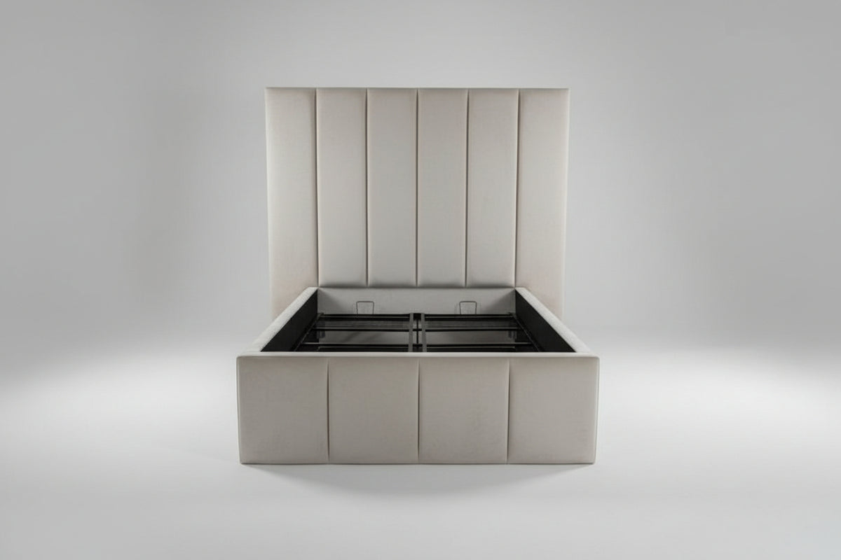 An upholstered platform bed frame with a matching padded headboard in a neutral cream or beige color, shown in a bedroom setting with carpeted floors and a white door in the background.